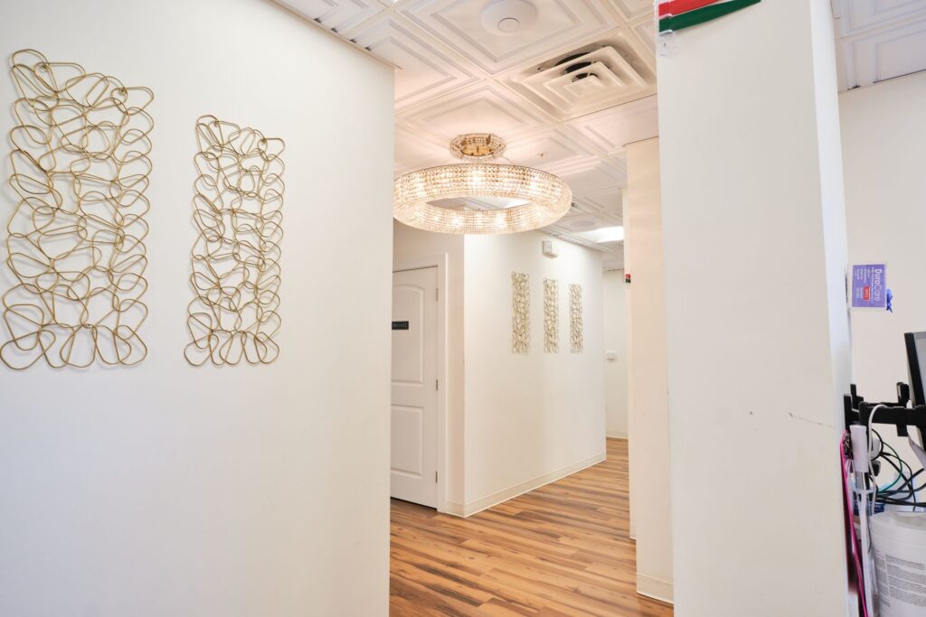 Bright dental office hallway with gold wall art and chandelier